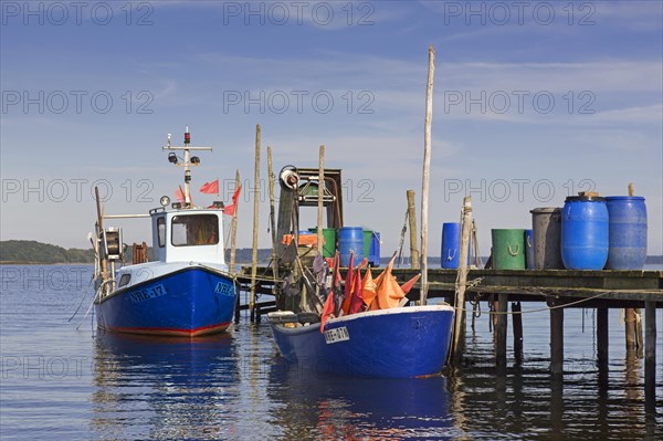 Fishing boats moored along wooden jetty at Neu Reddevitz