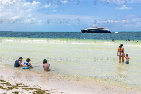 XCaret ferry boat from Isla Mujeres with people swimming in sea