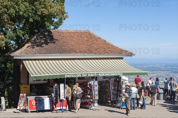 Tourists at the viewpoint in front of the Chateau du Haut Koenigsbourg. In the background the Upper Rhine Plain and the hilly landscape of the Black Forest