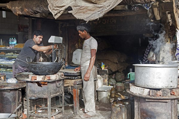 Man cooking food in dirty unsanitary primitive kitchen in Mathura