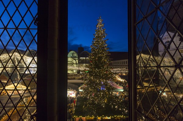 Huge decorated Christmas tree during Xmas fair on the market place in front of town hall in Luebeck