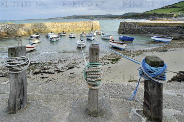 Knots in ropes of moored boats around wooden mooring posts at Port Racine