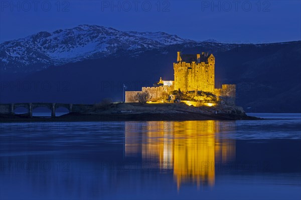 Illuminated Eilean Donan Castle in Loch Duich in winter at dusk