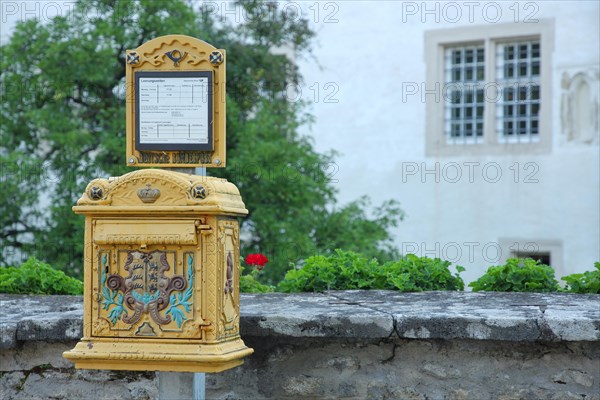 Historical yellow mailbox with ornaments