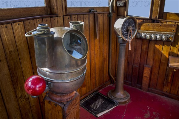 Old brass compass binnacle with iron correcting spheres at each side at bridge of ship