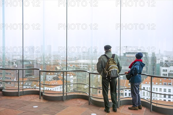 Elderly couple of tourists looking over the city Antwerp from the MAS