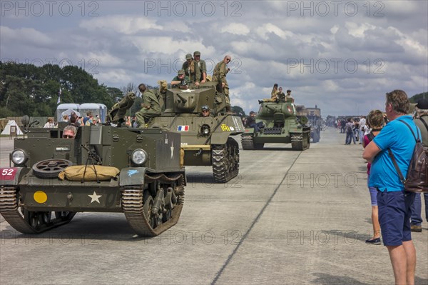 Visitors looking at parade of WW2 military armoured vehicles at World War Two militaria fair