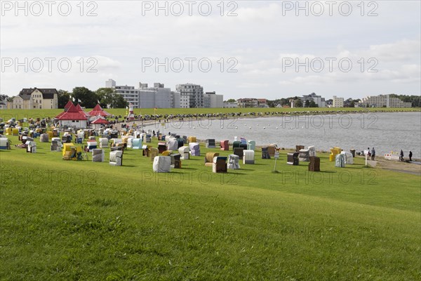 Beach chairs on a green meadow with dyke on the beach of Cuxhaven