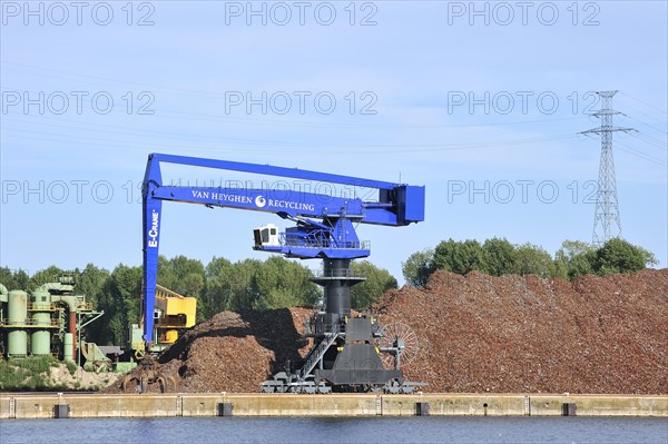 Dock crane and scrap heap along the Ghent-Terneuzen Canal at Ghent seaport