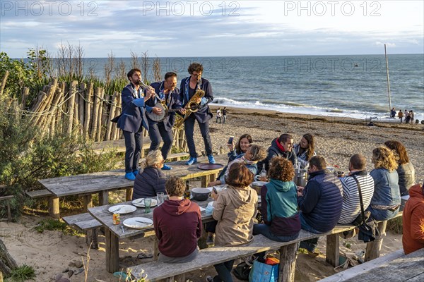 Live music on the tables at La Cale restaurant on the beach in Blainville-sur-Mer