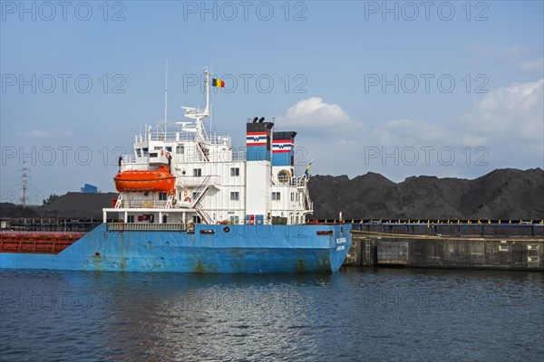 Bulk carrier docked in front of heaps of coal at SEA-invest