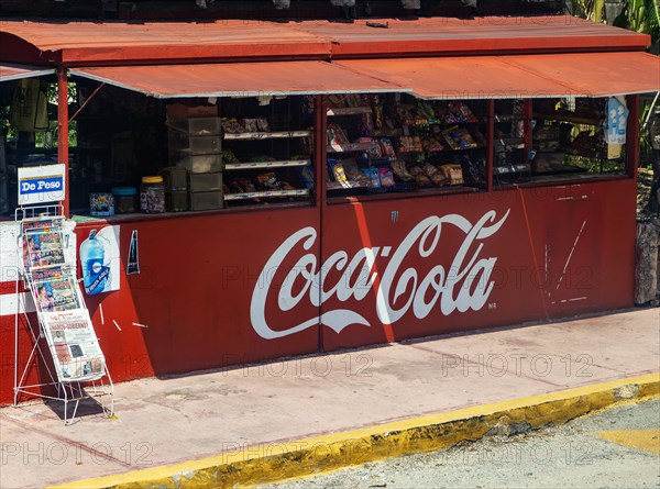 View from bus window of street snack shop labelled with Coca-Cola branding