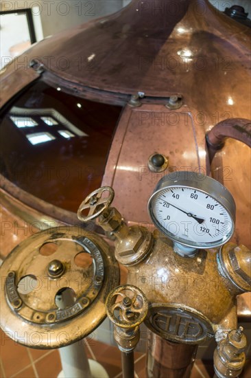 Gauge and valves on copper kettle of Trappist beer brewery in the Orval Abbey