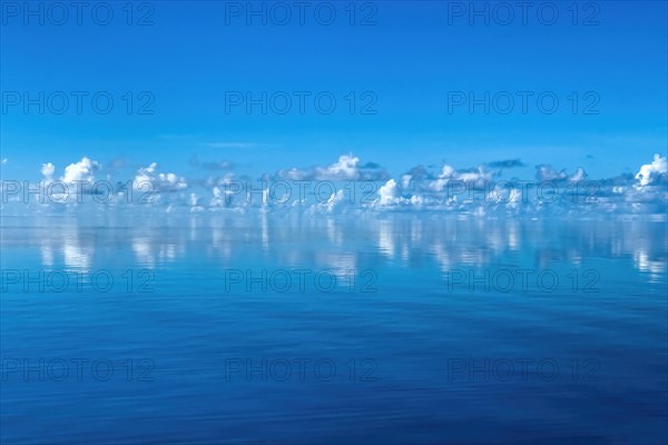 Clouds Altocumulus above Blue sky reflected on horizon over in Pacific Still ocean with no waves with in mirror smooth sea surface water surface mirror smooth sea