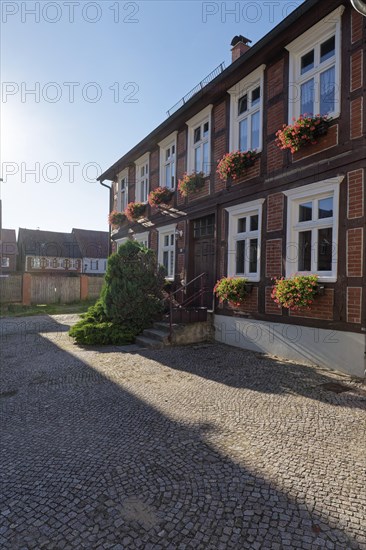 Half-timbered house decorated with flower boxes in the cobbled Lange Strasse in the Hanseatic town of Werben in the Altmark region. Werben