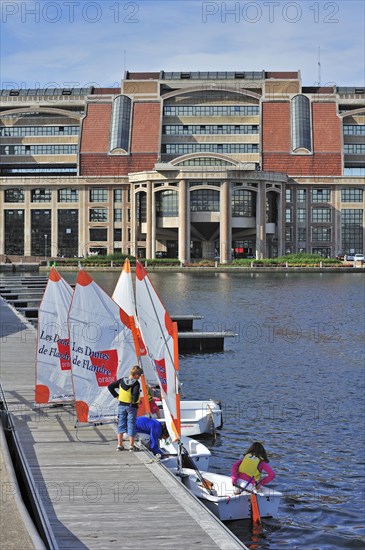 School children in sailing dinghies in front of the Hotel de la communaute urbaine