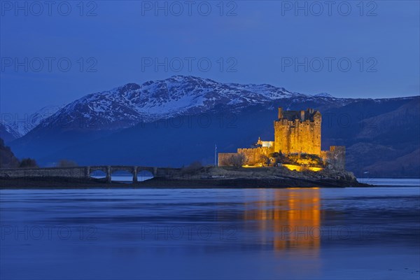 Illuminated Eilean Donan Castle in Loch Duich in winter at dusk