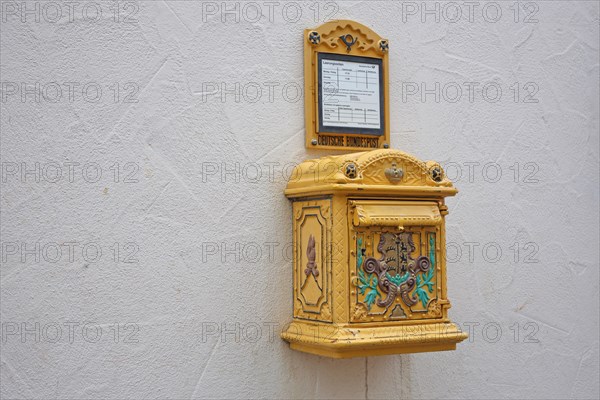 Historical yellow mailbox with ornaments