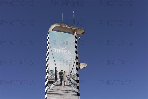 Advertising pillar Good Times with image of a holidaymaker couple