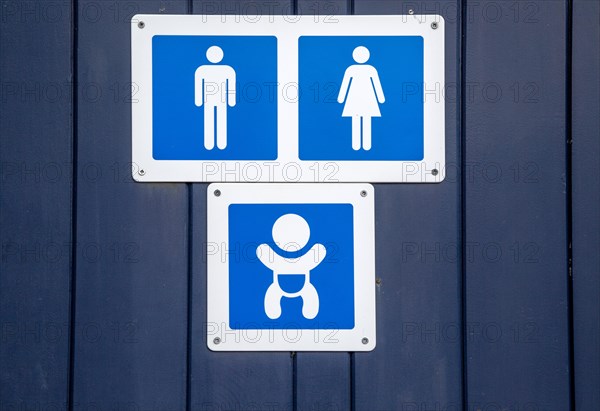 Male female unisex and baby changing signs on public toilets