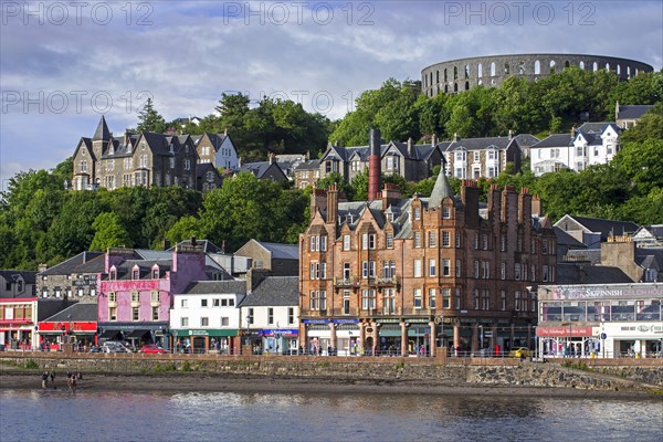 Shops and McCaig's Tower on Battery Hill overlooking the city Oban