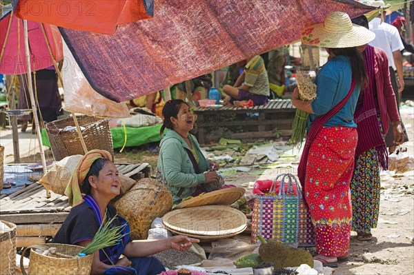 Burmese women selling vegetables at food market in village along Inle Lake
