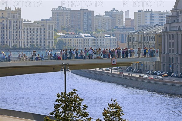 Tourists on the Floating Bridge over the Moskva River in Zaryadye Park in the city Moscow