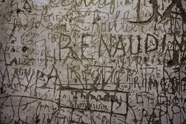 Old graffiti and scratchwork on wall inside the medieval Chateau de Bouillon Castle