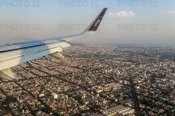 Oblique angle aerial view through plane window over Mexico City