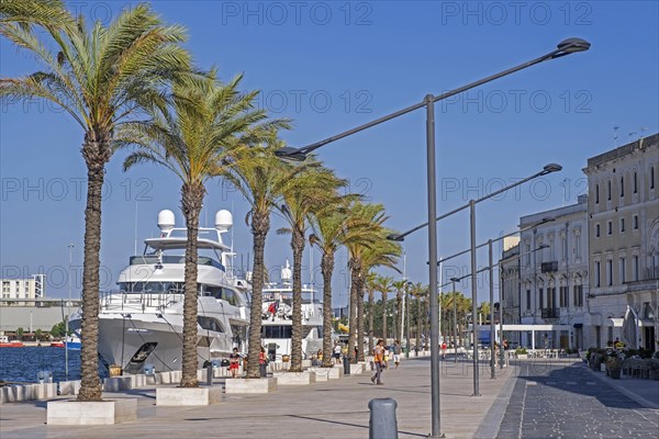 Promenade and motor yachts docked in the seaport