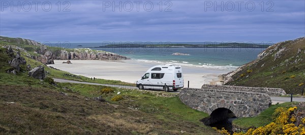 Motorhome driving on desolate road past Ceannabeinne Beach in summer near Durness