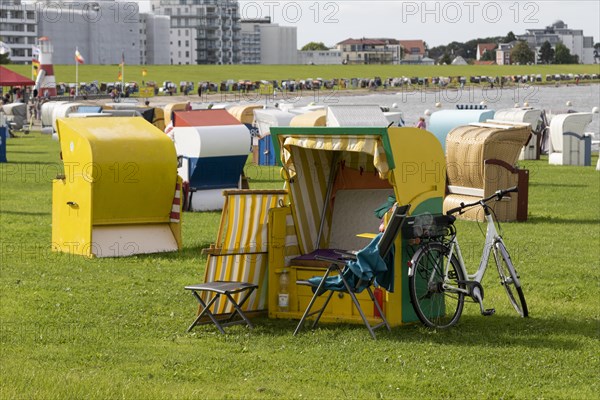 Beach chair with bicycle and deck chair on a green meadow at the beach of Cuxhaven