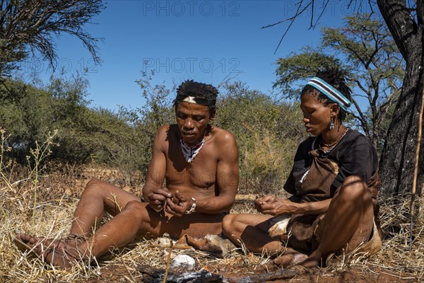 Bushman and San woman making fire in Kalahari