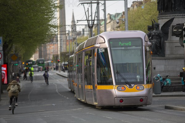 A Luas tram in O'Connell Street with cyclists visible too. Dublin