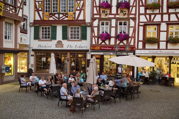 Gabled half-timbered houses on the busy medieval market square in the evening