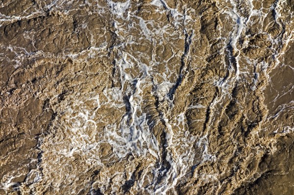 Turbulent muddy sea water caused by ship's screw causing turmoil in wake of boat