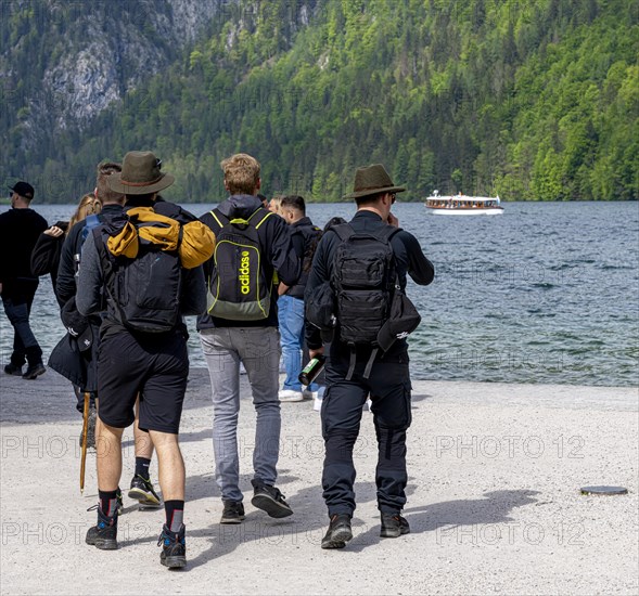 Hikers in traditional Bavarian traditional costume at Koenigssee in Berchtesgaden National Park