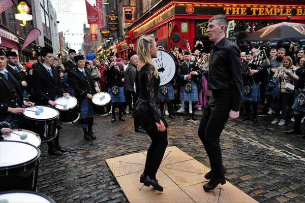 Dancers performing to music being played by the Clew Bay Pipe band in Temple Bar during Trad Fest. Temple Bar