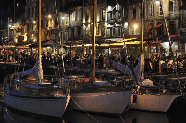 Sailing boats and tourists at pavement cafes