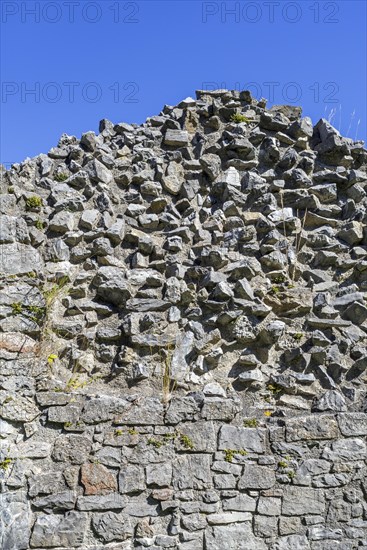 Thick stone wall of medieval castle showing two types of masonry