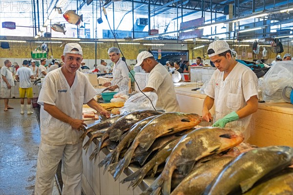 Fishmongers cleaning fishes at the covered fish market in the capital city Manaus