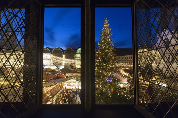 Huge decorated Christmas tree during Xmas fair on the market place in front of town hall in Luebeck