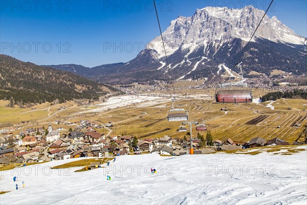 Plattensteig ski slope in the Grubigstein ski area with a view of the Zugspitze and the valley town of Lermoos