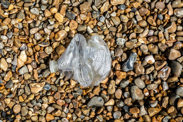 Crushed plastic bottle washed up on shingle beach