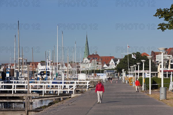 Tourists walking on the Promenade Vorderreihe along the river Trave at Travemuende