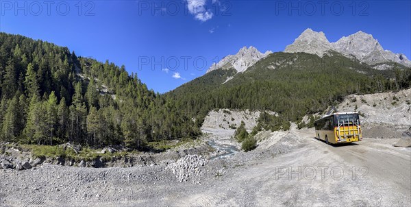 Postbus driving on gravel road in Val S-charl