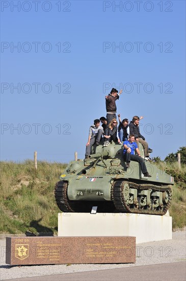 Teenagers on Second World War Sherman tank as monument near Utah Beach
