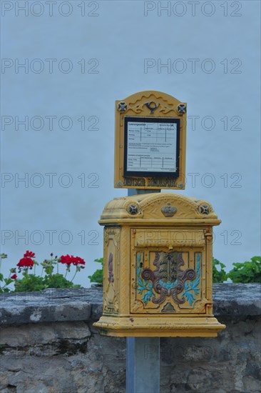 Historical yellow mailbox with ornaments