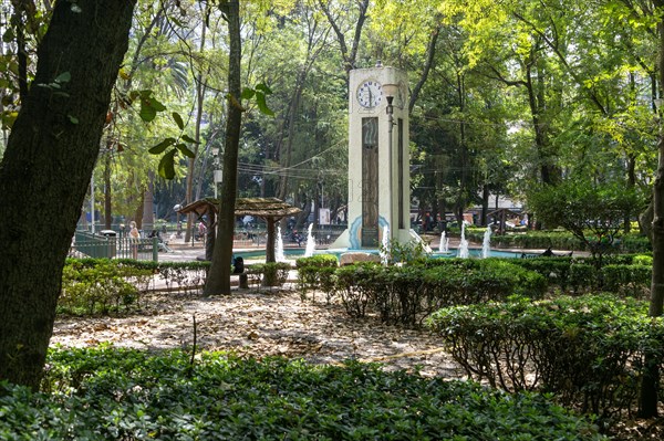 Clock tower trees and water fountains in Parque Mexico