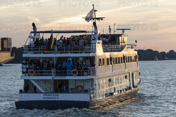 Party guests on the excursion ship MS Princess at dusk underway on the Elbe in Hamburg harbour